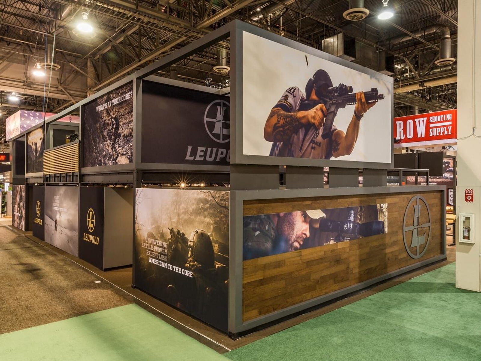 Stacked container-style exhibit with layered graphic modules and an elevated photo box